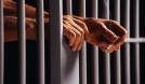 Prisoner Holding Cigarette Between Bars | The Law Office of Jim A. Trevino